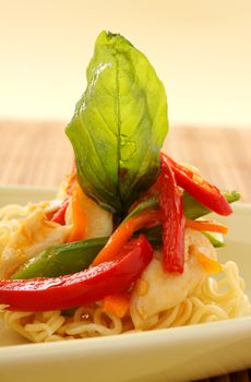 Delicious Asian chilli chicken on beds of crispy noodles with fried basil leaves.