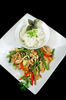 Delicious chicken stirfry and rice with almonds, asparagus, beans and peppers.