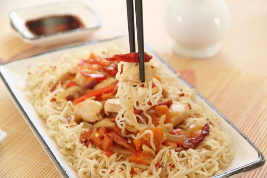 Serving a delicious chilli chicken stirfry with chopsticks.
