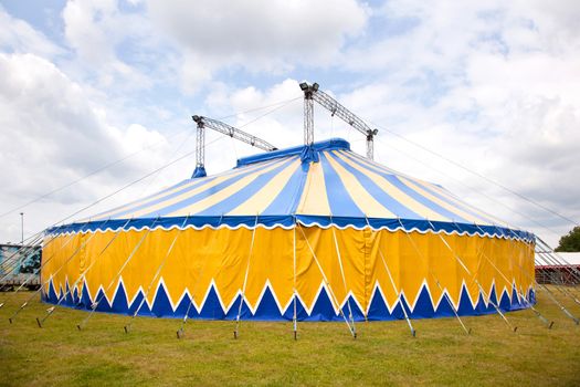circus tent in yellow and blue in the grass