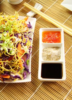 Chinese condiments consisting of soy sauce, chinese spicy salt and sweet chilli sauce with a noodle salad.
