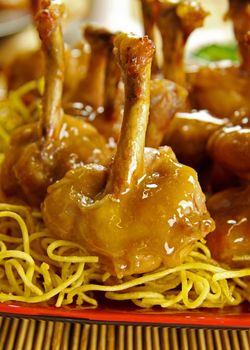 Delicious chicken drumettes on a bed of noodles.