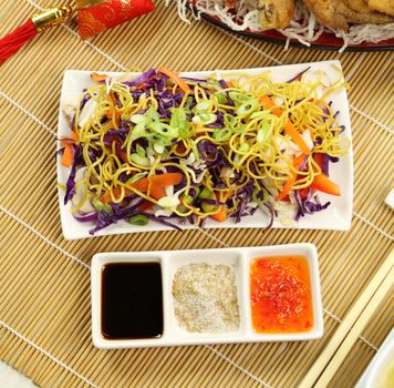 Chinese coleslaw with condiments consisting of soy sauce, chinese spicy salt and sweet chilli sauce.