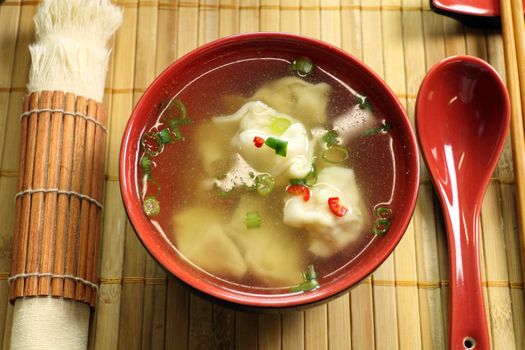 Delicious Chinese short soup with dumplings and diced shallots.