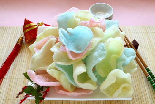 Delicious crispy Asian prawn crackers with spearmint leaves ready to serve.