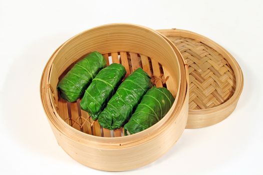 Delicious Asian chicken cabbage rolls in a bamboo steamer.