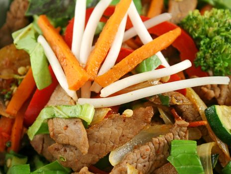 Stirfry beef and vegtables with a purple green basil garnish.