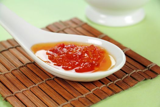 Sweet chilli sauce in a spoon ready to serve.