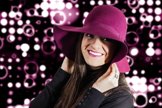 Portrait of beautiful young girl with a garnet hat on her head, in front of spotlights background