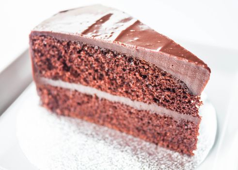 Piece of chocolate sponge cake on white plate