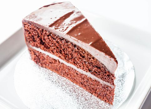 Piece of chocolate chiffon cake on white dish