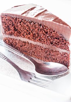 Piece of chocolate cake with spoon and fork