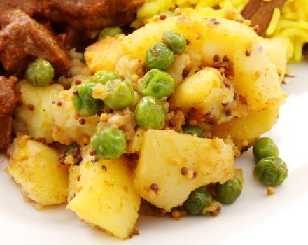 Delicious spicy tumeric potatoes and green peas.
