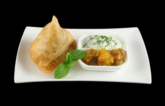 Indian samosa with mango chutney and herb yogurt.