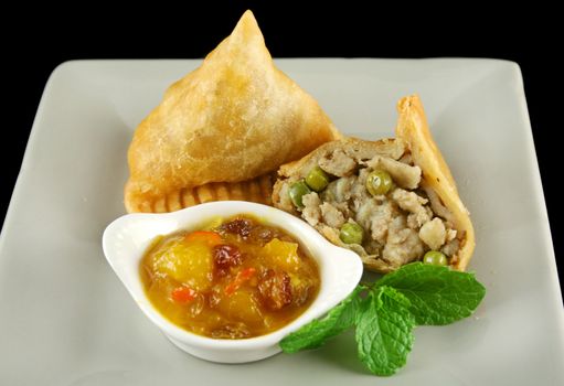 Indian samosa with mango chutney and herb yogurt.