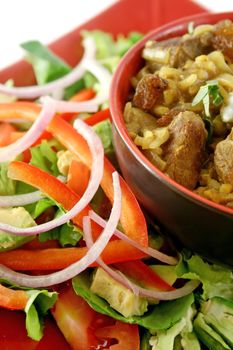 Indian lamb biryani with sultanas and yoghurt and a side salad.