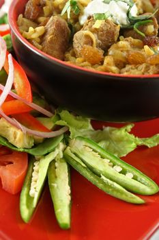 Indian lamb biryani with sultanas and yoghurt and a side salad.