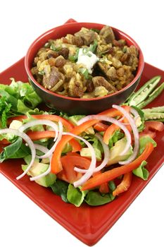 Indian lamb biryani with sultanas and yoghurt and a side salad.