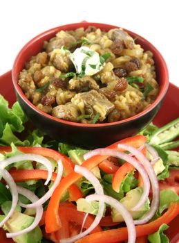 Indian lamb biryani with sultanas and yoghurt and a side salad.