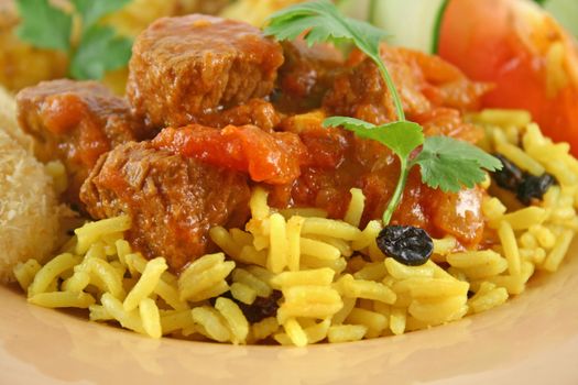 Beef vindaloo curry on tumeric rice with a side salad.