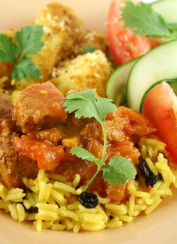 Beef vindaloo curry on tumeric rice with a side salad.