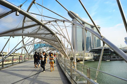Singapore, Republic of Singapore - May 03, 2013: People strolling on the Helix Bridge in Singapore. The Helix is fabricated from 650 tonnes of Duplex Stainless Steel and 1000 tonnes of carbon steel.