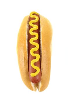 Mustard on a hot dog and bread roll on a white background.
