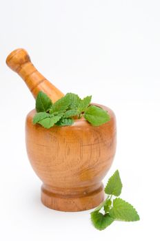 wooden mortar with melissa leaves