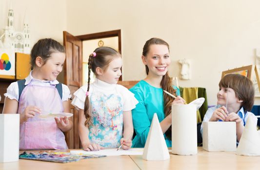 children draw with the teacher in the classroom drawing