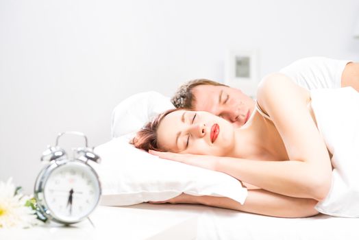 young beautiful woman sleeping on the bed with her husband