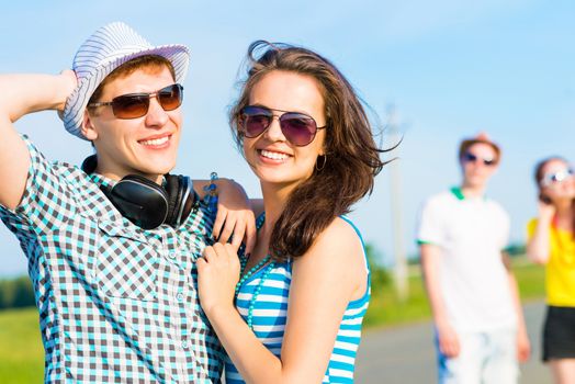 young couple standing on the road, having fun with friends