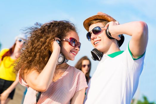 young couple standing on the road, having fun with friends