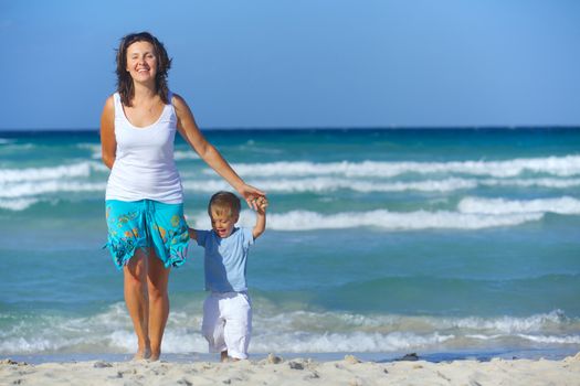 Happy beautiful mother and son enjoying beach time