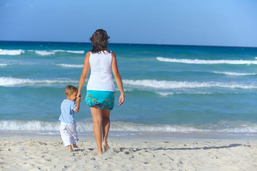 Happy beautiful mother and son looking on the sea.