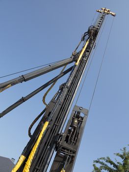 Pile-driver in action against the blue sky.