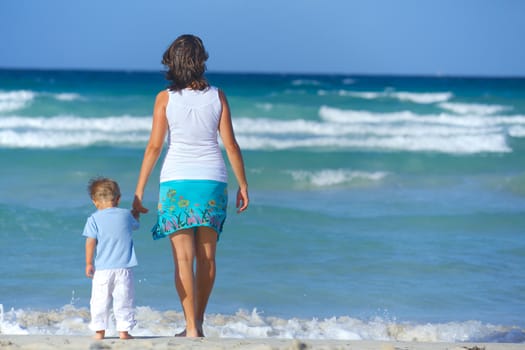 Happy beautiful mother and son looking on the sea.