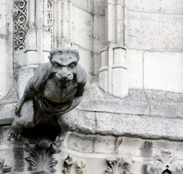 A lone, outstretched stone gargoyle appears to be soaring straight out from Notre Dame Cathedral, Paris, France