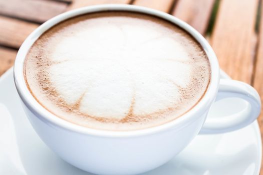 Serving cup of hot cafe mocha on wooden table