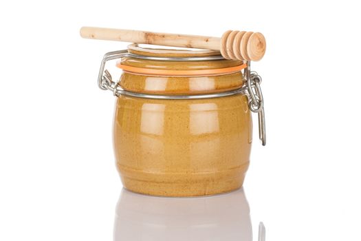 Honey pot and stick isolated on white background close up.