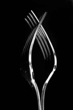 Close up of two forks on a black background