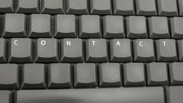 Top view of word contact spelled on computer keyboard.