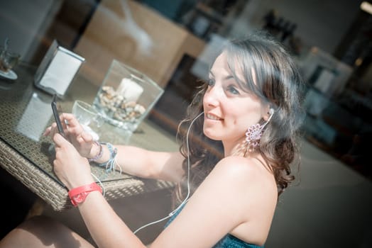 young beautiful woman listening to music at the coffee