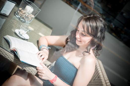 young beautiful woman reading book at the coffee