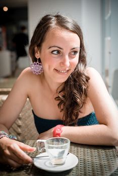 young beautiful woman drinking coffee at the coffee bar