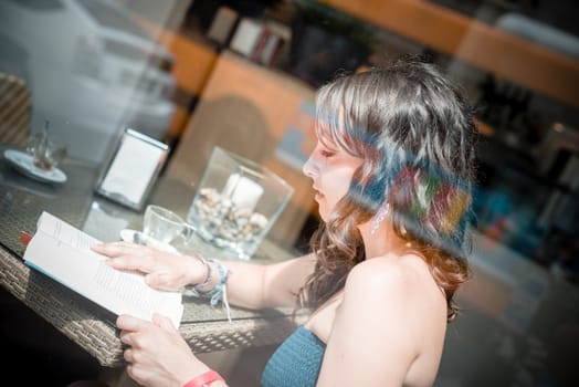 young beautiful woman reading book at the coffee