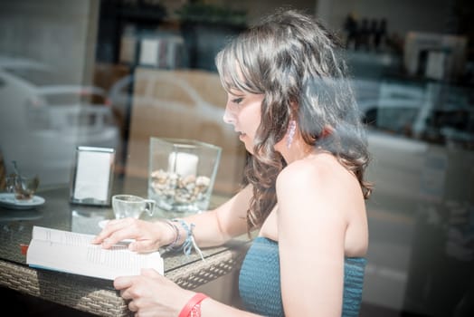 young beautiful woman reading book at the coffee