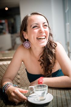 young beautiful woman drinking coffee at the coffee bar