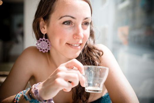 young beautiful woman drinking coffee at the coffee bar