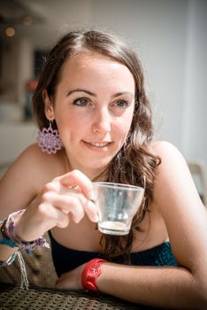 young beautiful woman drinking coffee at the coffee bar