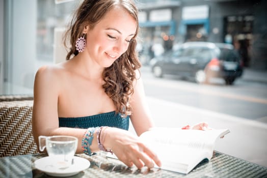 young beautiful woman reading book at the coffee